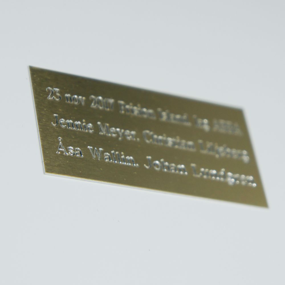 Guldskylt med graverad text