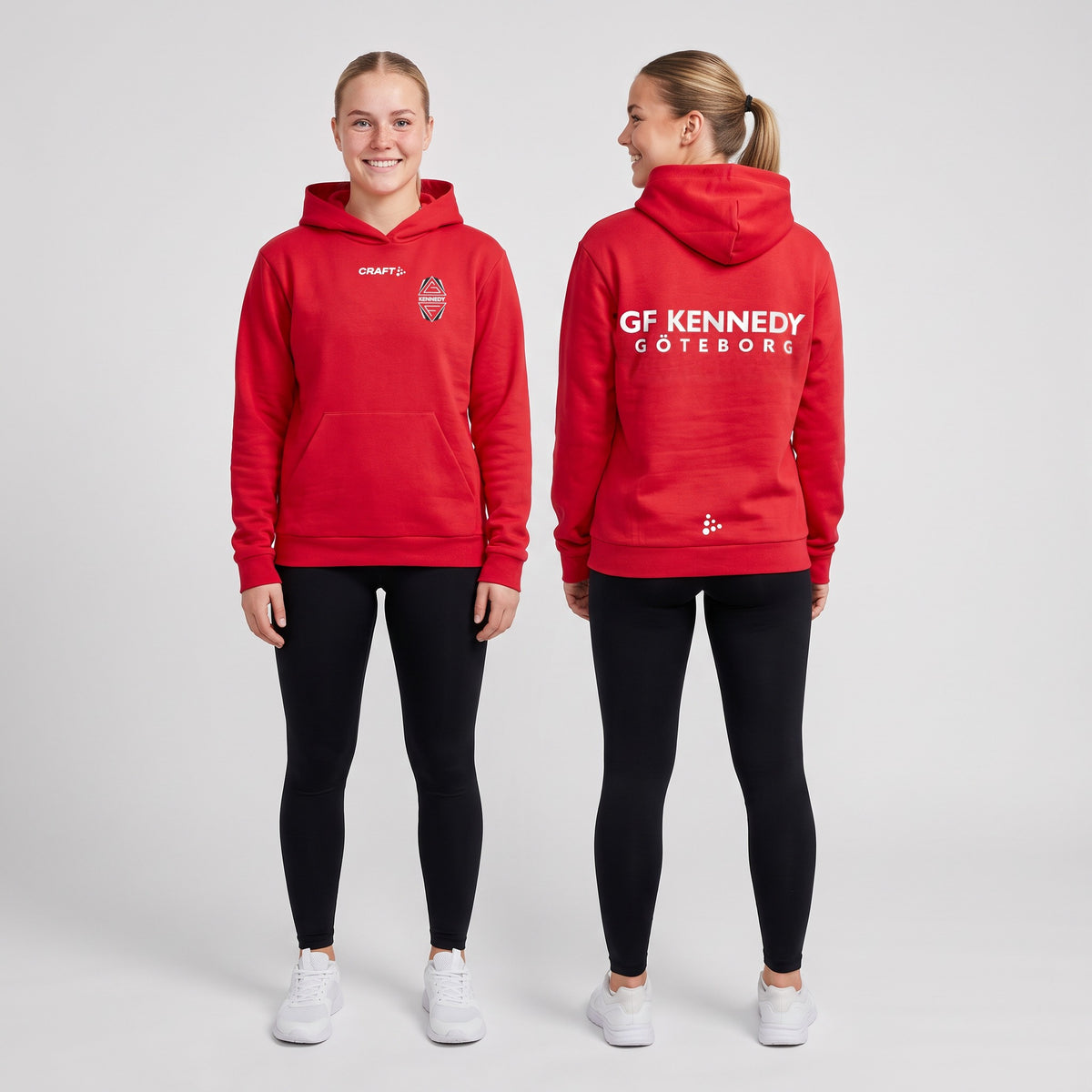 Två unga kvinnor i röd Craft Community 2.0 hoodie dam med GF Kennedys klubbemblem på bröstet och textloggan GF Kennedy Göteborg på ryggen
