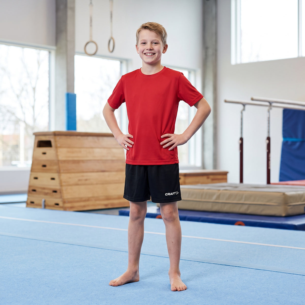 Kille i svarta Craft Squad Go shorts junior i en gymnastikhall